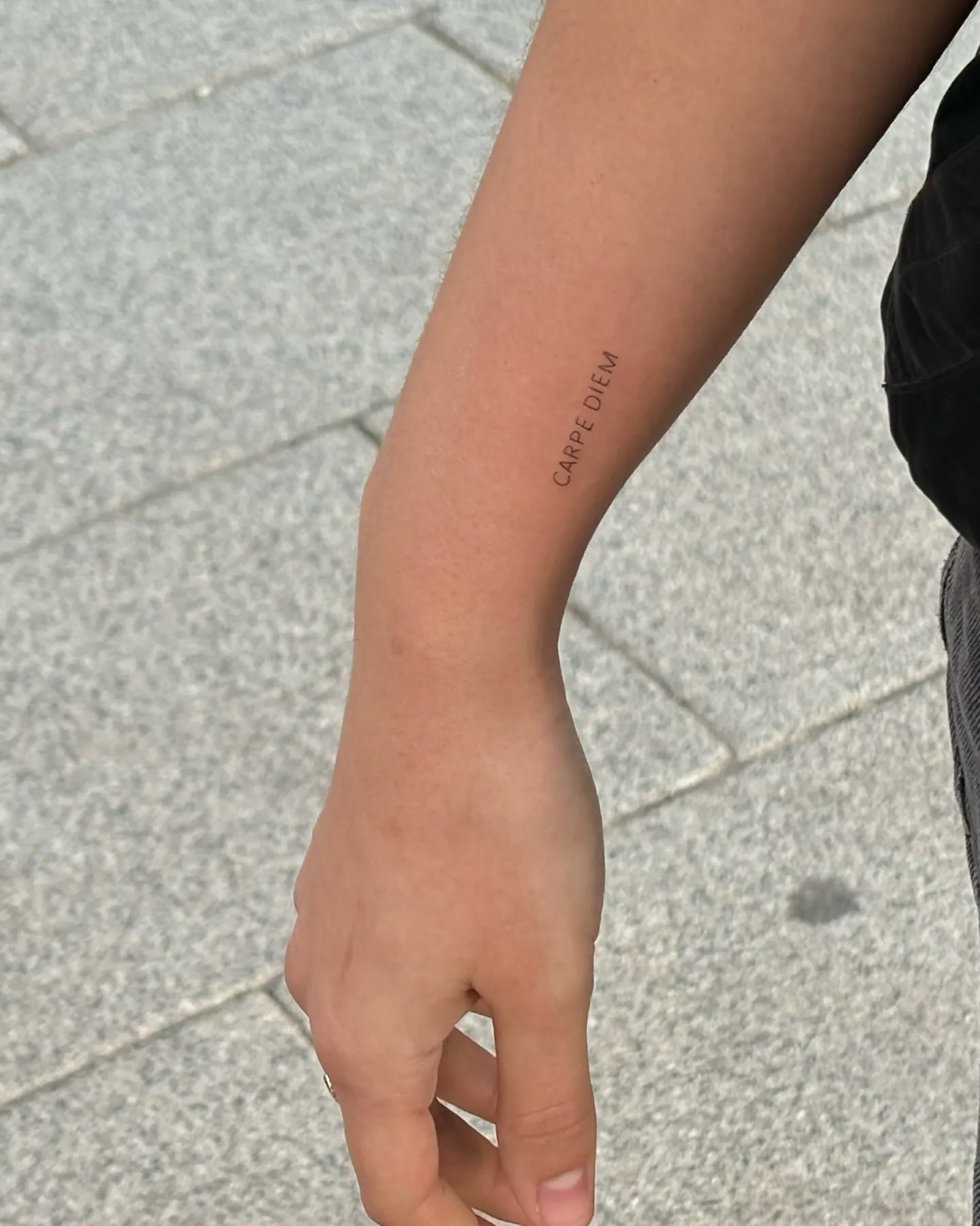 Feines Schriftzug Tattoo Carpe Diem am Unterarm