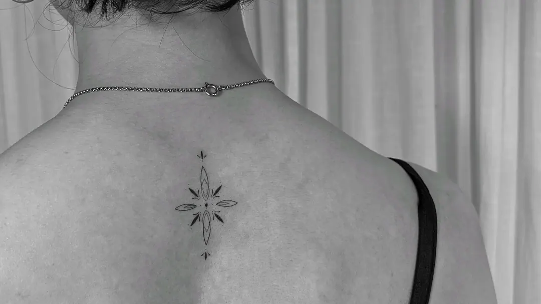Feines Tattoo mit Mondphasen und Zierlinien im oberen Rücken